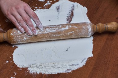 Kadın eller şef yakın çekim, hamur yoğurun, bir masada hamur pişirin