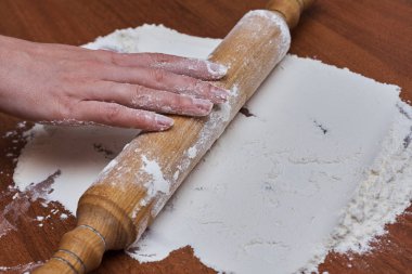 Kadın eller şef yakın çekim, hamur yoğurun, bir masada hamur pişirin