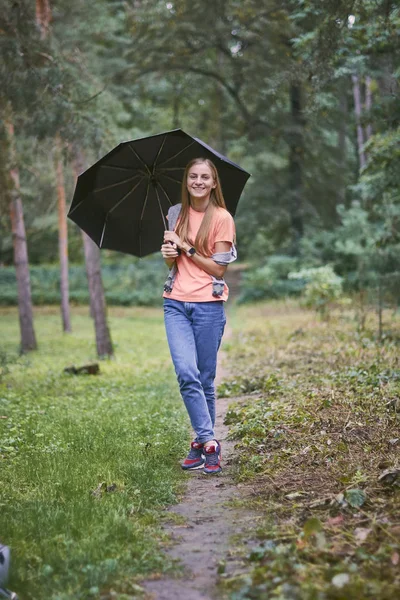 Young woman with umbrella in the forest