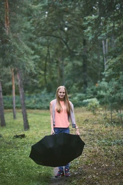 Young woman with umbrella in the forest