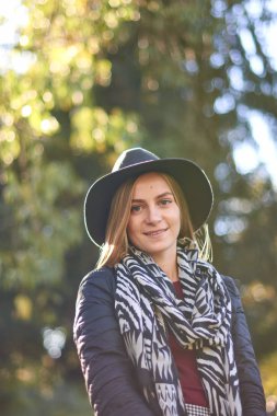 Güz parkında güzel genç bir kadın.