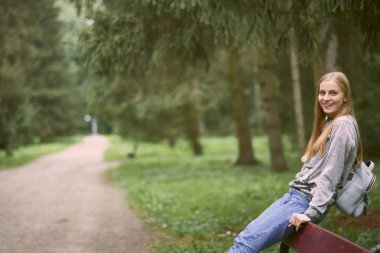 Parkta sırt çantası ile genç kadın 