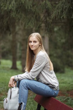 Parkta sırt çantası ile genç kadın 