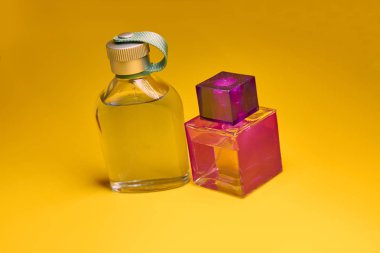 Sarı arka planda parfüm şişeleri. Minimal stil