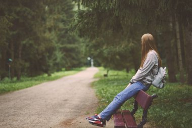 Parkta sırt çantası ile genç kadın 