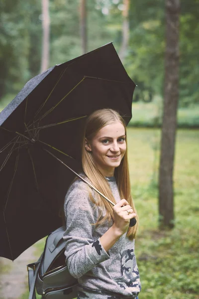 Young woman with umbrella in the forest