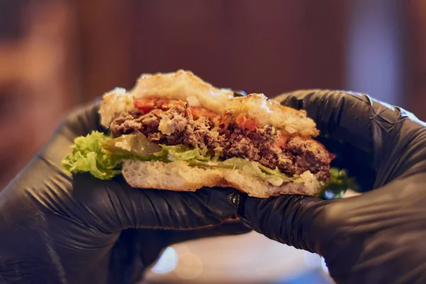 freshly prepared burger in chef hands