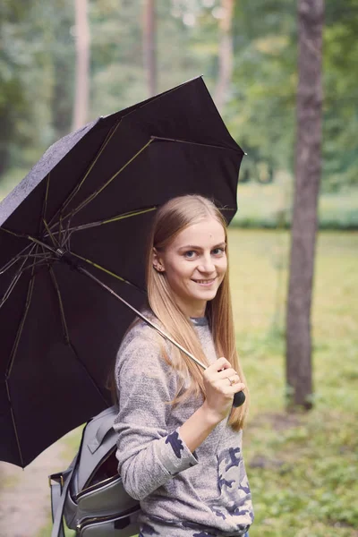 Young woman with umbrella in the forest