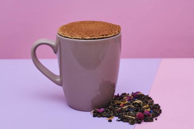 waffle sıcak kahve veya çay fincan üstüne yerleştirilen pembe arka plan üzerinde servis