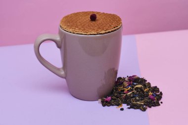 waffle sıcak kahve veya çay fincan üstüne yerleştirilen pembe arka plan üzerinde servis