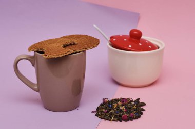 pembe arka plan üzerinde servis sıcak kahve veya çay fincan üstüne yerleştirilen waffle