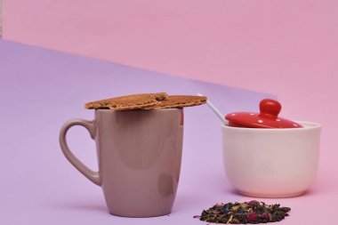 pembe arka plan üzerinde servis sıcak kahve veya çay fincan üstüne yerleştirilen waffle