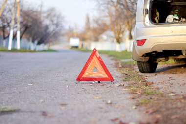Kırmızı üçgen sembolü kırık araba uyarmak için yolda yer almaktadır. Yolda Acil stop araba, Kırık araba kavramı.