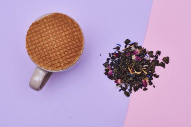 waffle sıcak kahve veya çay fincan üstüne yerleştirilen pembe arka plan üzerinde servis