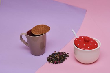 pembe arka plan üzerinde servis sıcak kahve veya çay fincan üstüne yerleştirilen waffle