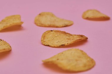 pembe bir arka plan üzerinde taze pişmiş patates cipsi