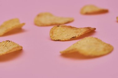 pembe bir arka plan üzerinde taze pişmiş patates cipsi