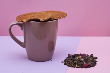 pembe arka plan üzerinde servis sıcak kahve veya çay fincan üstüne yerleştirilen waffle