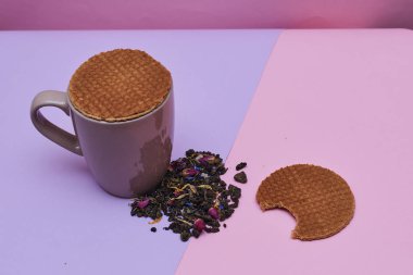 pembe arka plan üzerinde servis sıcak kahve veya çay fincan üstüne yerleştirilen waffle
