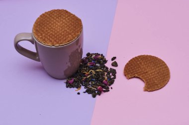 pembe arka plan üzerinde servis sıcak kahve veya çay fincan üstüne yerleştirilen waffle