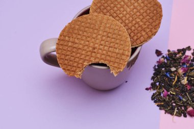 pembe arka plan üzerinde servis sıcak kahve veya çay fincan üstüne yerleştirilen waffle