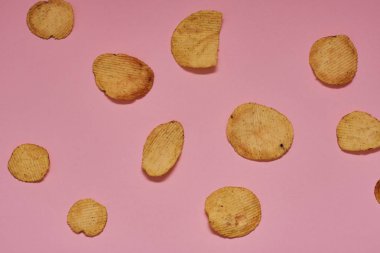 pembe bir arka plan üzerinde taze pişmiş patates cipsi
