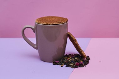 pembe arka plan üzerinde servis sıcak kahve veya çay fincan üstüne yerleştirilen waffle