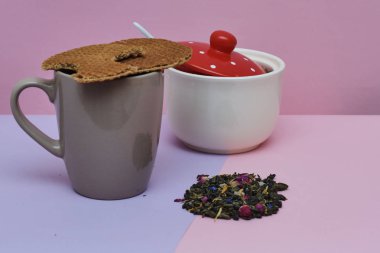 pembe arka plan üzerinde servis sıcak kahve veya çay fincan üstüne yerleştirilen waffle