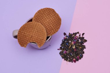 pembe arka plan üzerinde servis sıcak kahve veya çay fincan üstüne yerleştirilen waffle