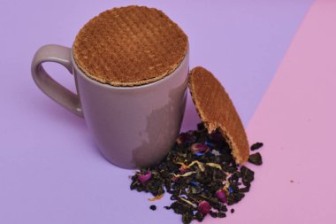 waffle sıcak kahve veya çay fincan üstüne yerleştirilen pembe arka plan üzerinde servis