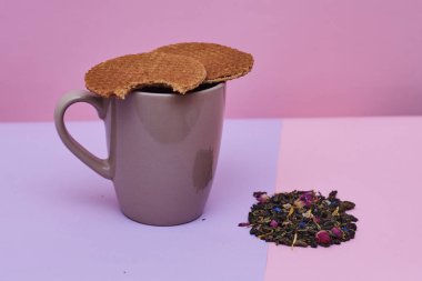 pembe arka plan üzerinde servis sıcak kahve veya çay fincan üstüne yerleştirilen waffle