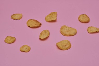 pembe bir arka plan üzerinde taze pişmiş patates cipsi