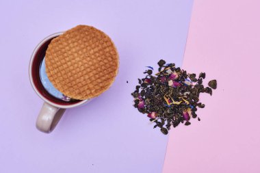 waffle sıcak kahve veya çay fincan üstüne yerleştirilen pembe arka plan üzerinde servis