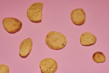 pembe bir arka plan üzerinde taze pişmiş patates cipsi