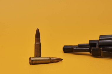 Silah ve mermiler sarı arkaplanda