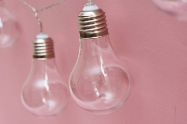 Pembe arka planda klasik ampul çelenkleri. 