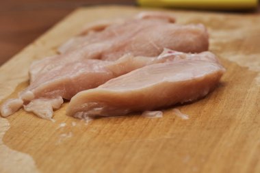 Tahta üzerinde dilimlenmiş tavuk göğsünün yakın plan görüntüsü. 