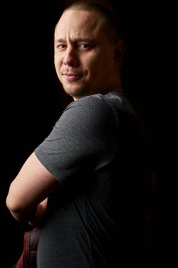 Siyah arka planda izole edilmiş kameraya bakan yakışıklı bir gencin portresi.  