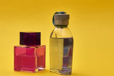 Sarı arka planda parfüm şişeleri. Moda parfüm şişeleri.