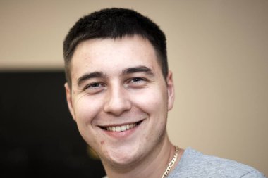 Kameraya gülümseyen yakışıklı bir gencin portresi, yakın çekim.