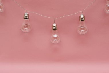 Pembe arka planda klasik ampul çelenkleri. 