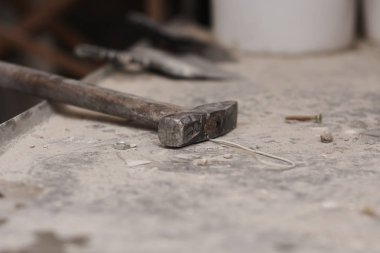 Beton bir yüzeyin duvarında çivili paslı bir çekiç.