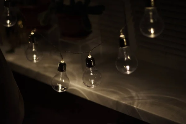 Garland of vintage lamp bulbs on dark background