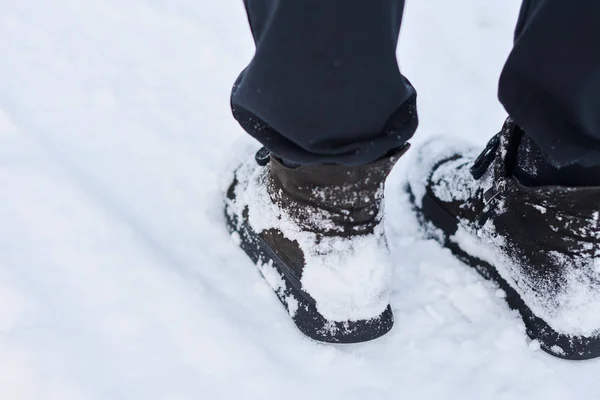 Woman feet in snow boots, closeup.