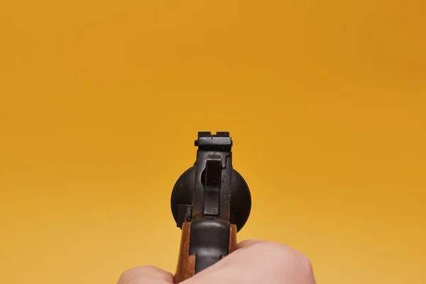 Oříznutý Záběr Osoby Držící Revolver Žlutém Pozadí — Stock fotografie