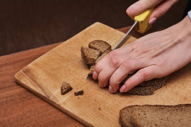 Taze çavdar ekmeği dilimleyen bir kadın resmi.