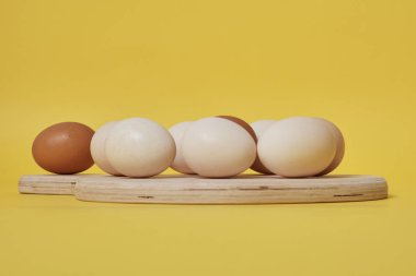 Tahtadaki yumurtalar parlak sarı arkaplanda.