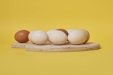 Tahtadaki yumurtalar parlak sarı arkaplanda.