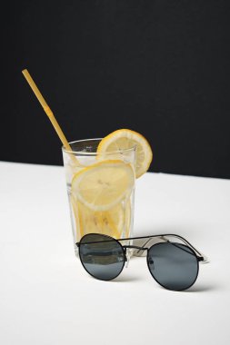 Beyaz masada saman ve güneş gözlüğü ile limonata Cam
