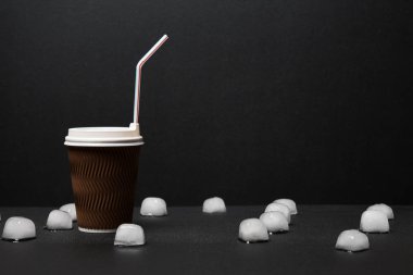 Siyah arka planda pipet içmek için buz ve kahvenin yakın plan görüntüsü  